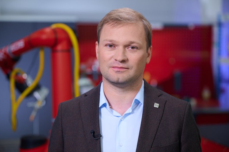 Артем Лукин на фоне роботов.jpg